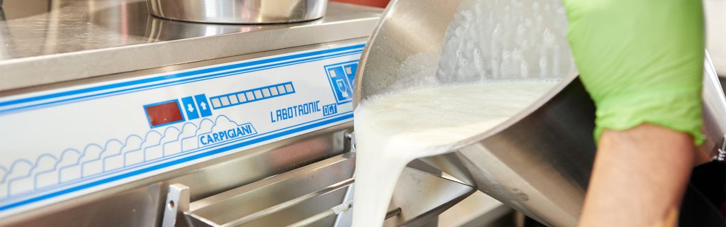 Zeigt das Eingießen der Milch bei der traditionelle Eis-Herstellung in Rheinbach